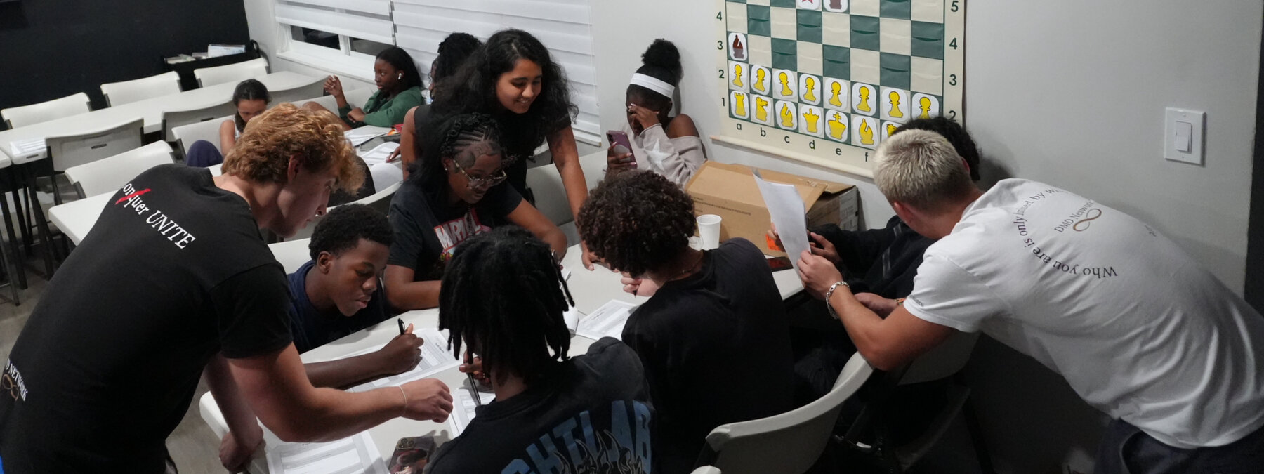 Students huddled around a table working through a peer-led activity