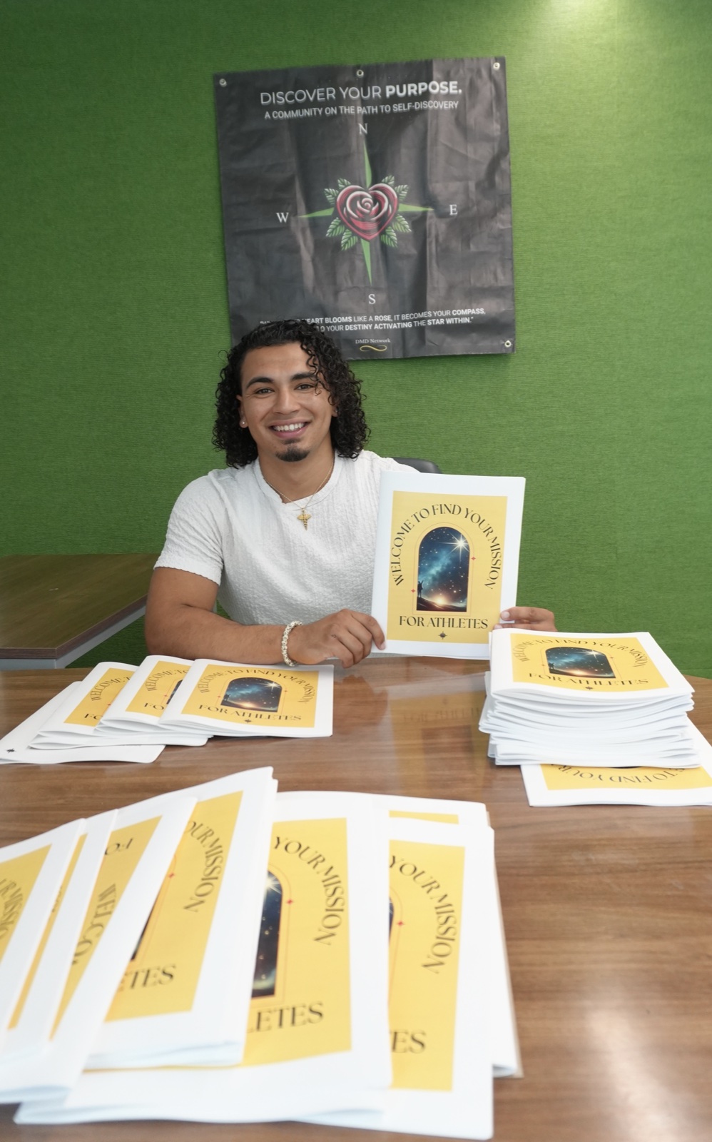 Daniel with copies of the Find Your Mission for Athletes workbook