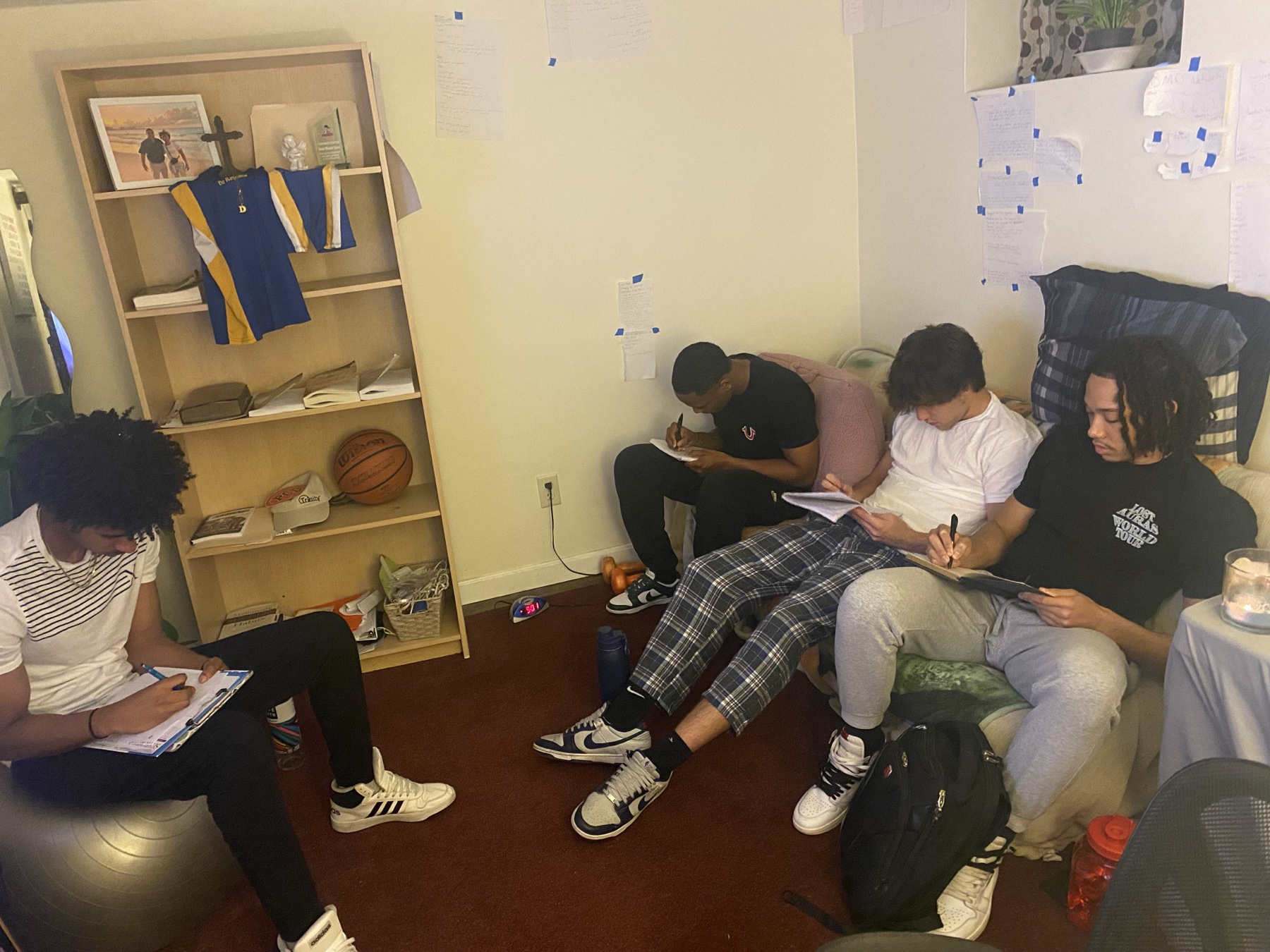 Teammates gathered together, writing and reflecting in a small room
